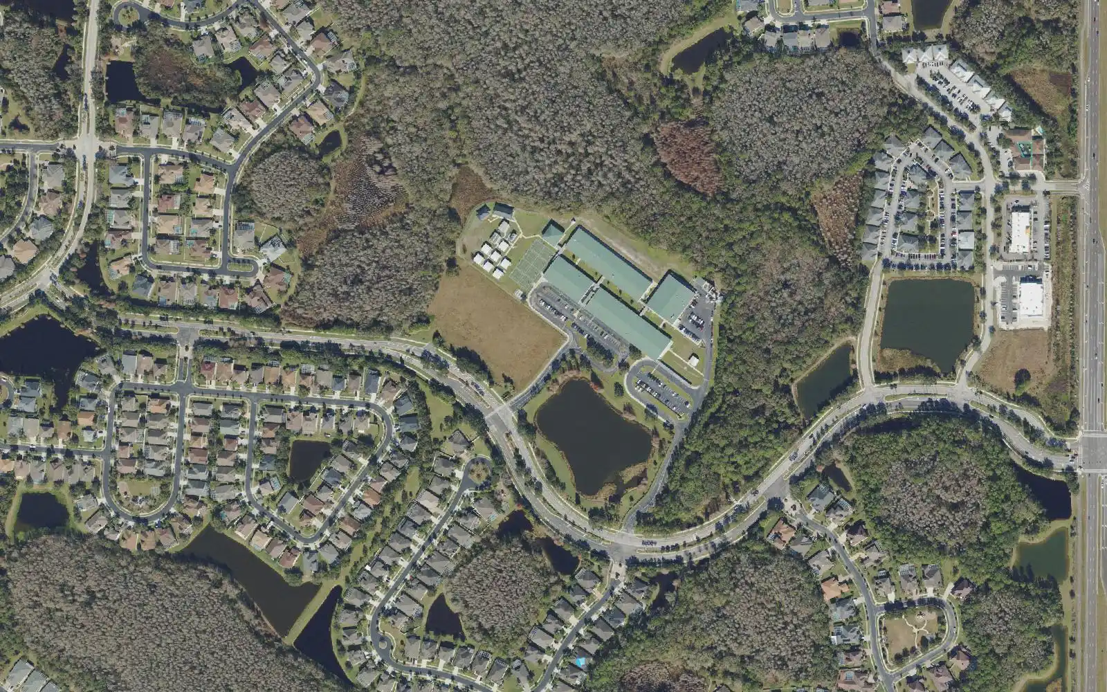 Seven Oaks Elementary School on Mystic Oak Boulevard, right of center, surrounded by homes, lakes and woods in an aerial view of Seven Oaks.