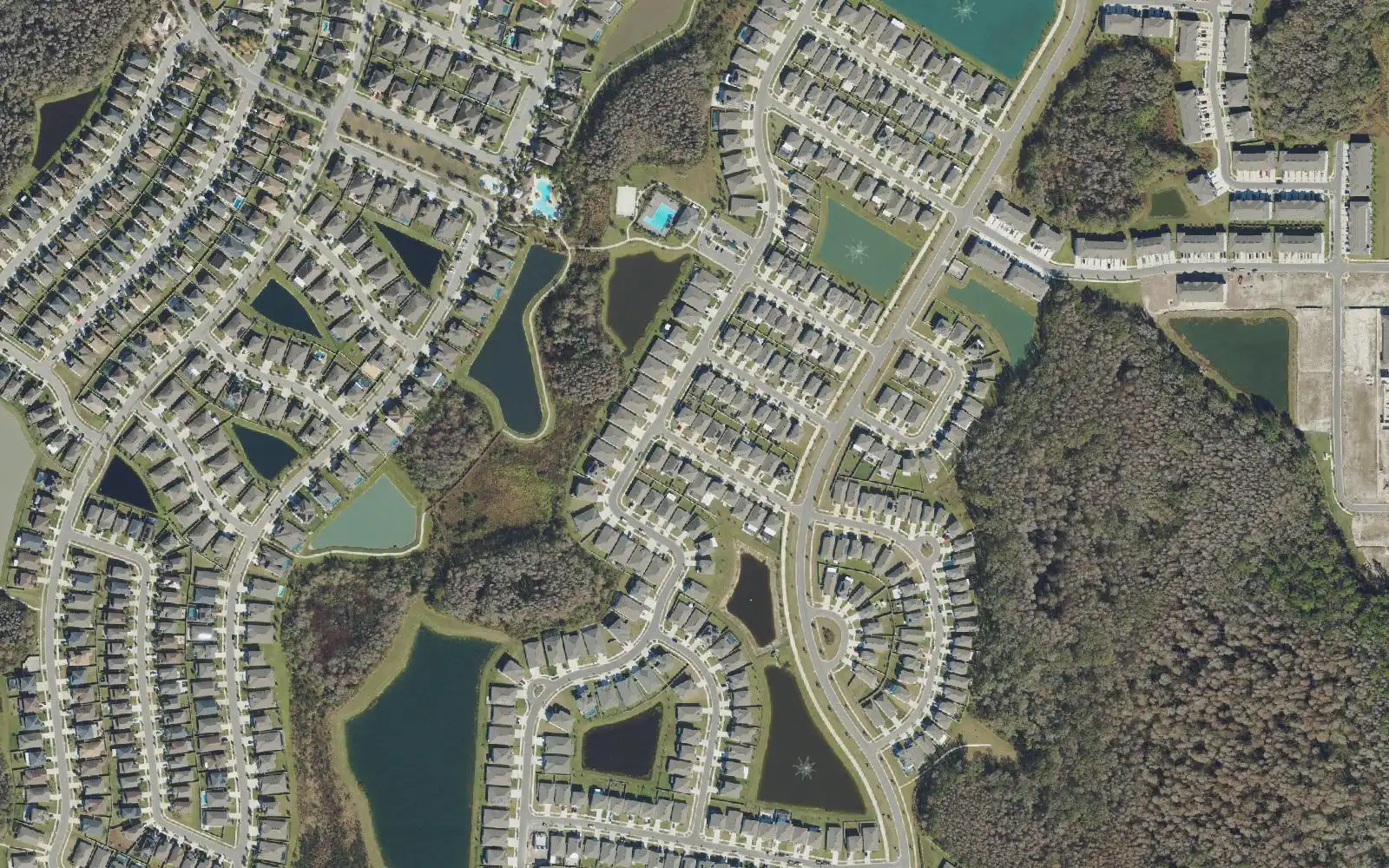 Rows of homes around stormwater ponds, with two community pools near the upper center, in an aerial view of Union Park.