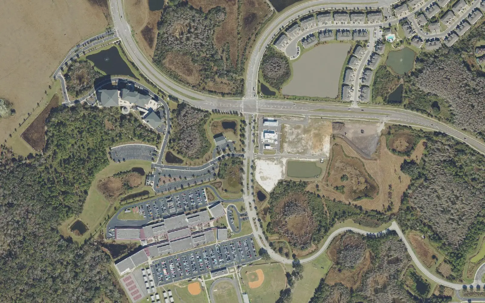 Wiregrass Ranch High School and its playing fields at the bottom of the frame, with streets of homes and stormwater ponds above it, in an aerial view of Wiregrass Ranch.