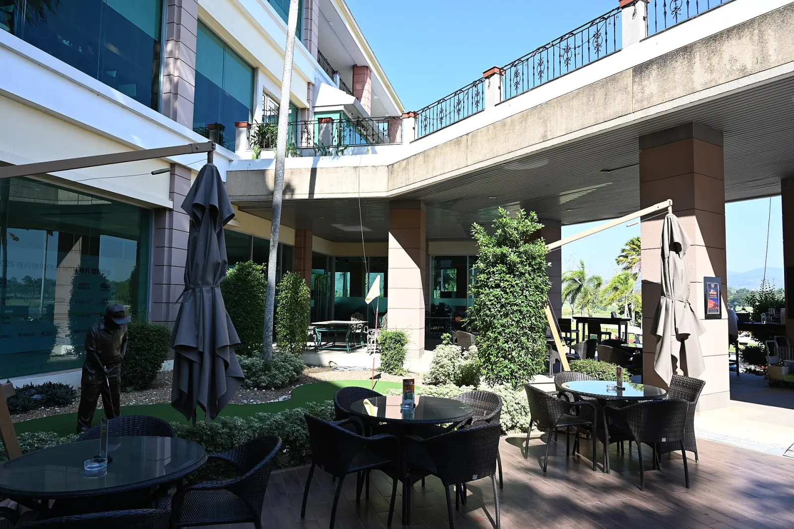 Tables, chairs and umbrellas on a restaurant patio in a building courtyard. The photo was not taken in Wesley Chapel.