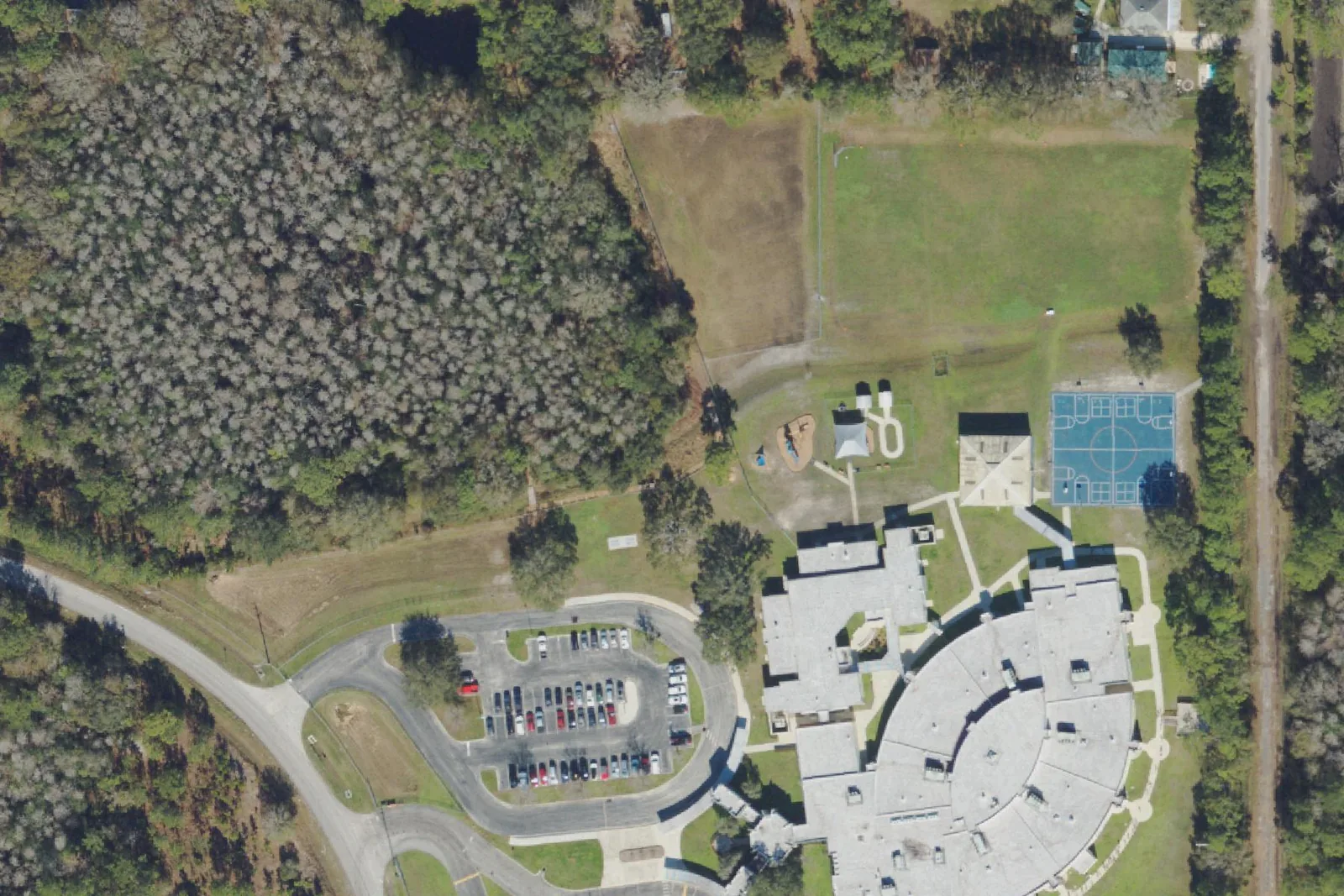 Quail Hollow Elementary School's round classroom building and parking lot on Quail Hollow Boulevard, seen from the air.