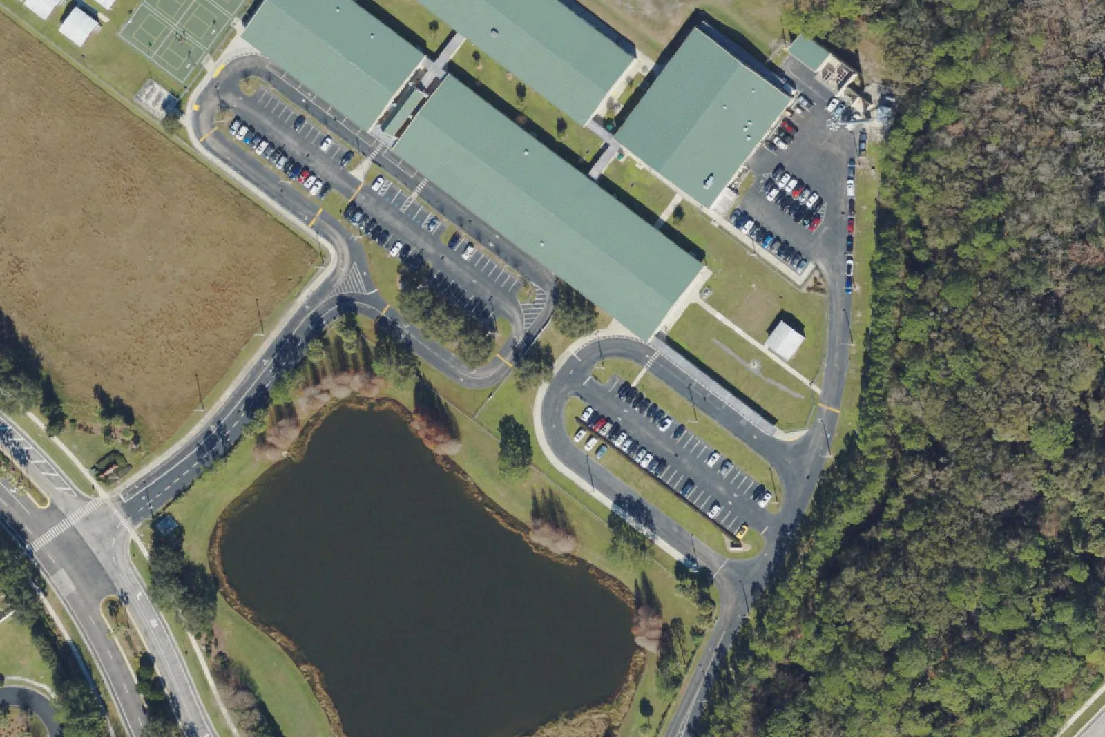 Seven Oaks Elementary School's green-roofed classroom buildings and pond on Mystic Oak Boulevard in Wesley Chapel, seen from the air.