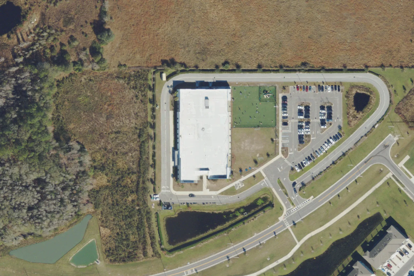 Union Park Charter Academy's school building, parking lot and car loop on Oldwoods Avenue in Wesley Chapel, seen from the air.