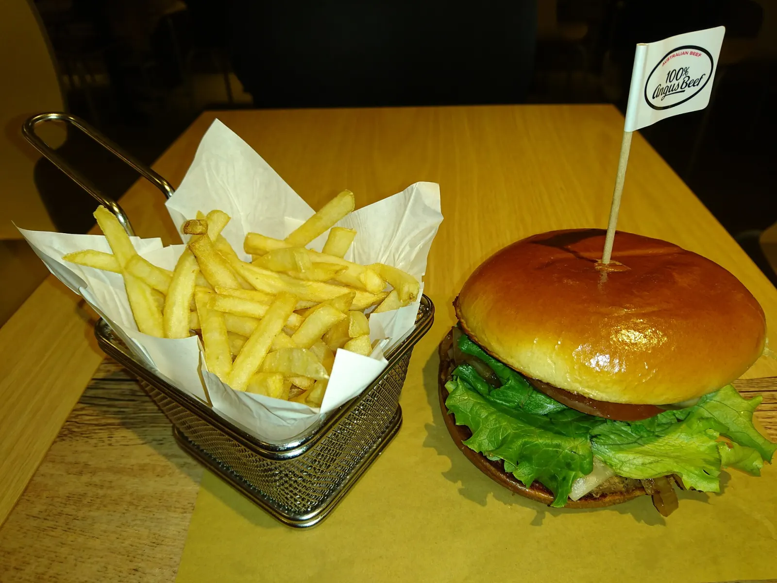 A cheeseburger with lettuce and tomato beside a basket of fries. The photo was not taken in Wesley Chapel.