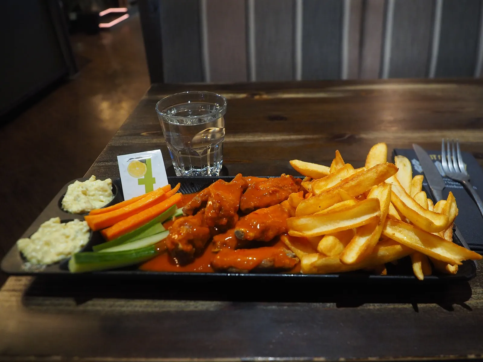 A plate of Buffalo wings with fries, carrot and celery sticks and dip. The photo was not taken in Wesley Chapel.